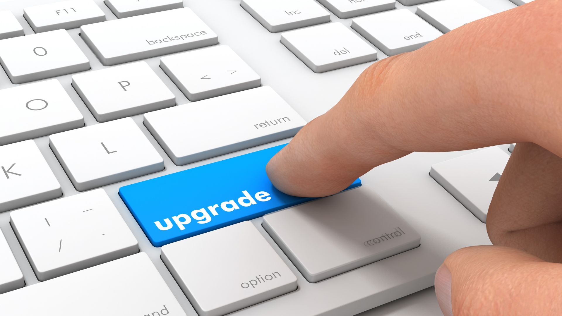 Finger pressing a blue upgrade key on keyboard, symbolizing upgrade your business website