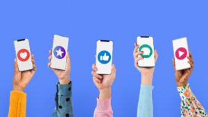 Hands holding smartphones with social media icons on screens, representing the importance of a small business social media presence.
